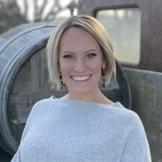 Natalie Frazier in front of wine barrels