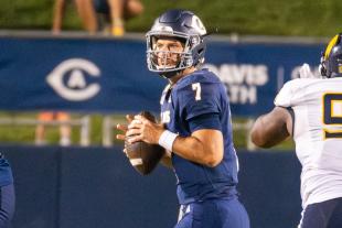 Miles Hastings holding a football on the field