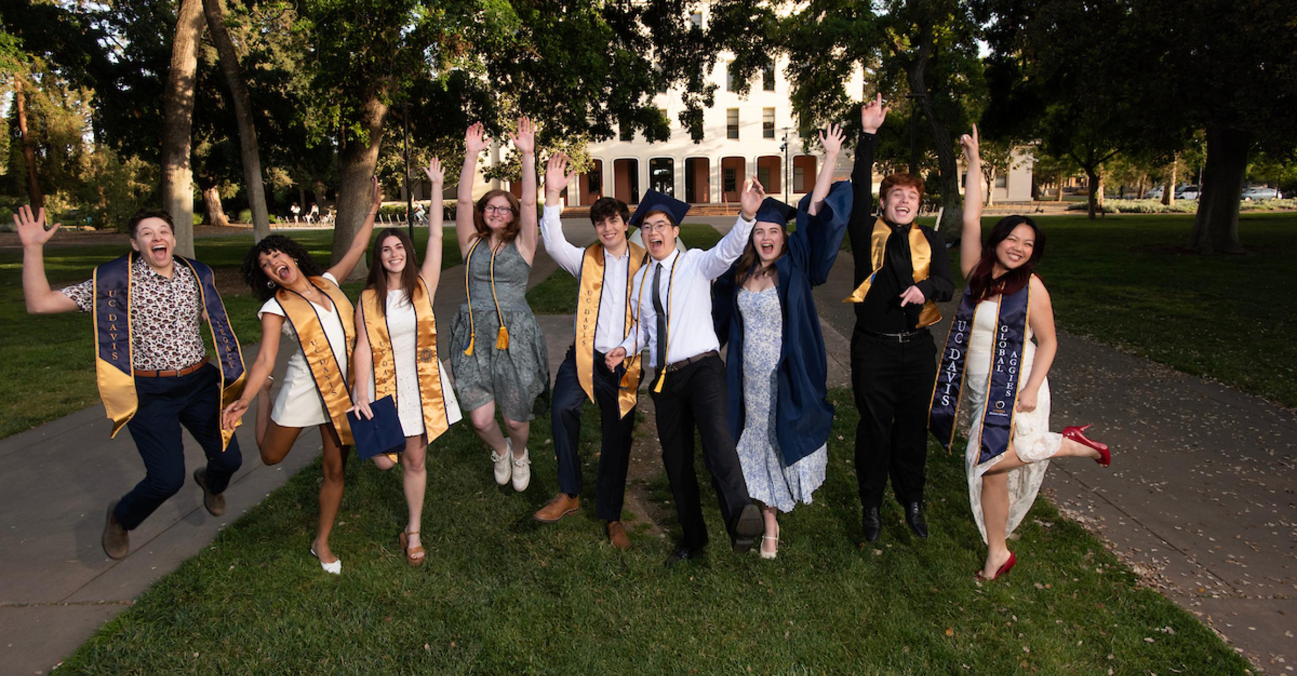 undergraduates jumping at commencement