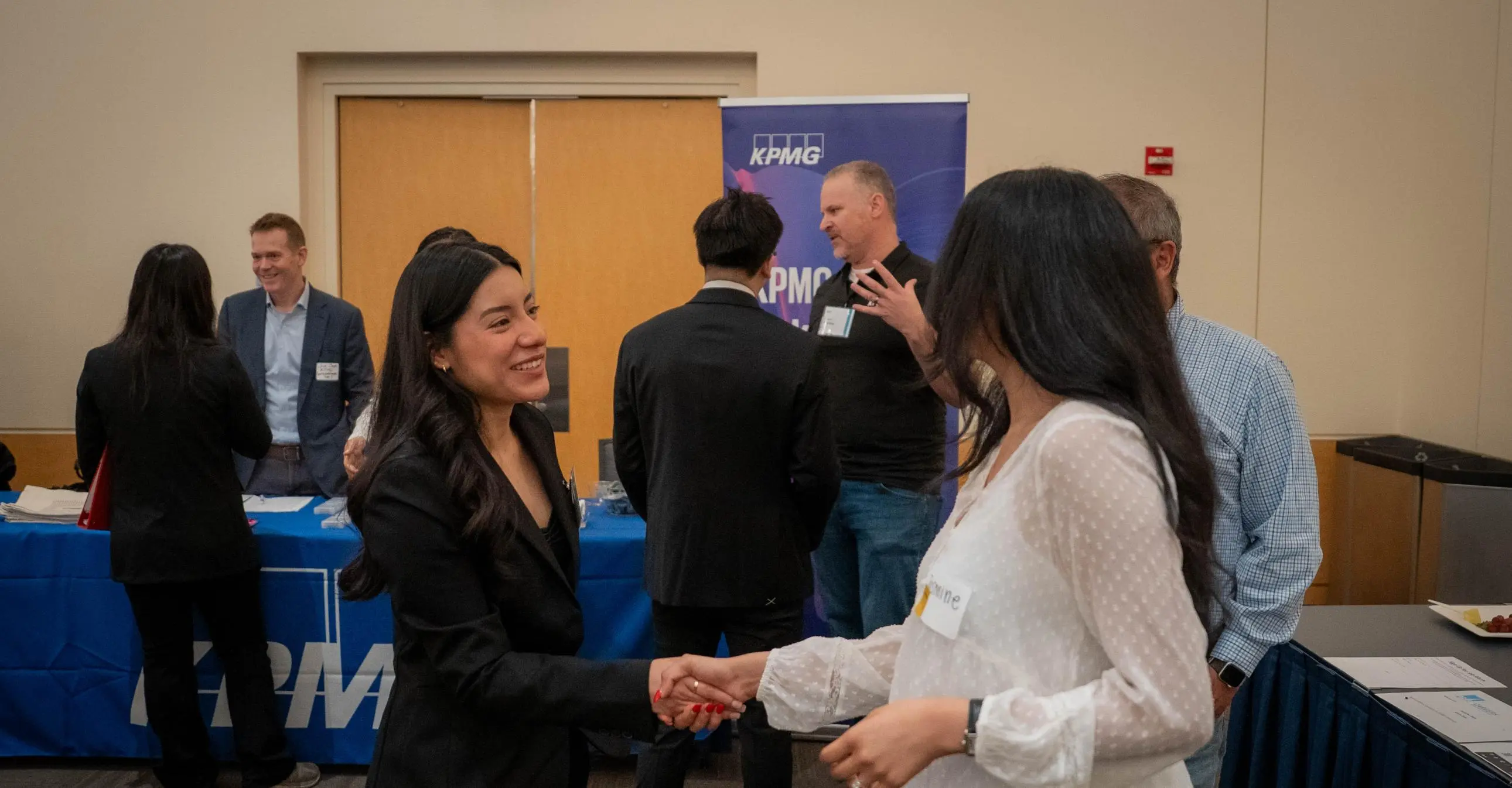 An MPAc student and a recruiter shake hands at the Meet the Firms event