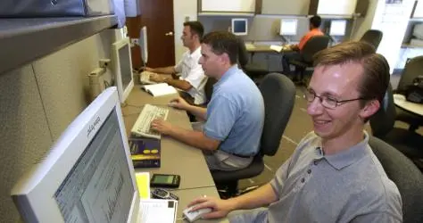 Three MBA students in a computer lab