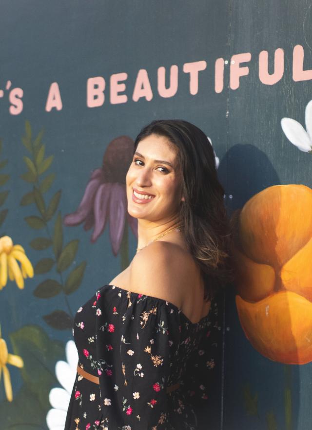 Leticia Garay standing in front of a flower mural