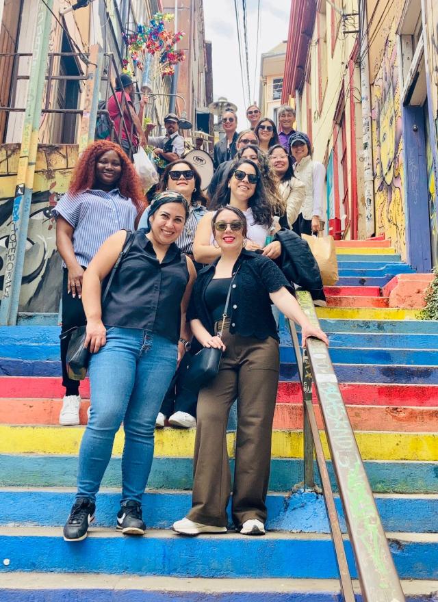 MBA students in Chile, standing on a colorful outdoor staircase