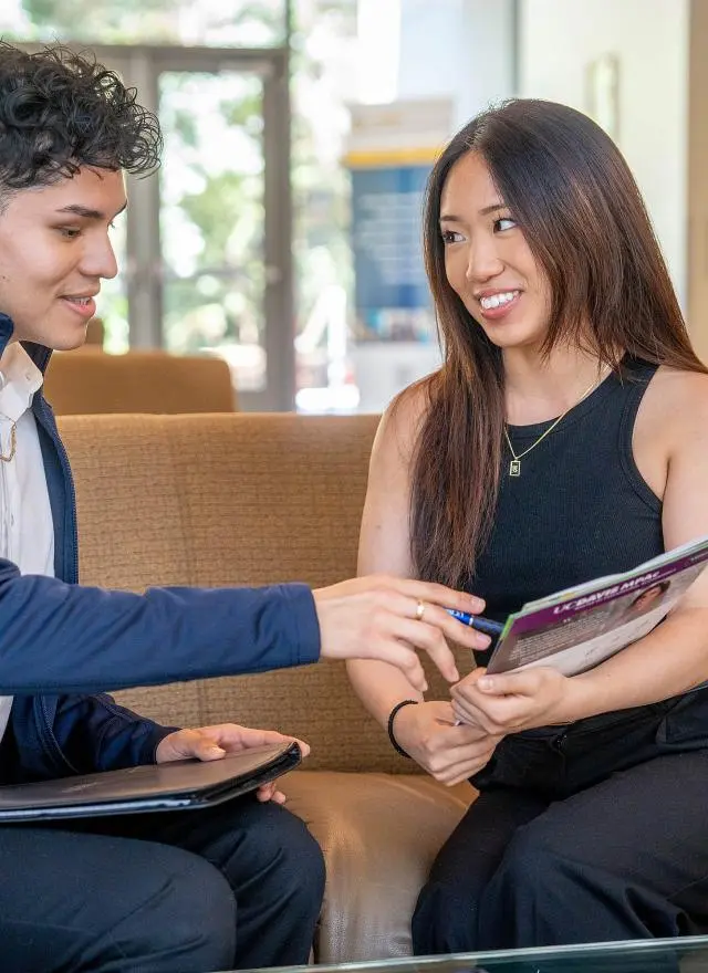 Two MPAc students reviewing a flyer in Gallagher Hall