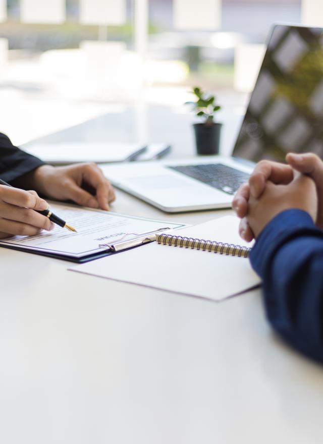 two people sitting at a desk in an office setting