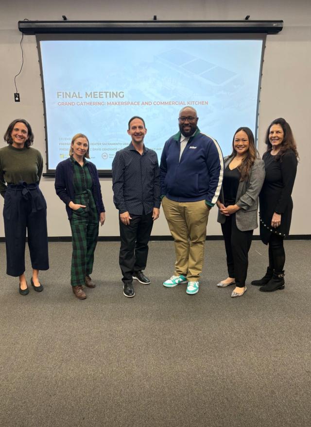 Liza Santa Ana and MBA students in front of a presentation screen
