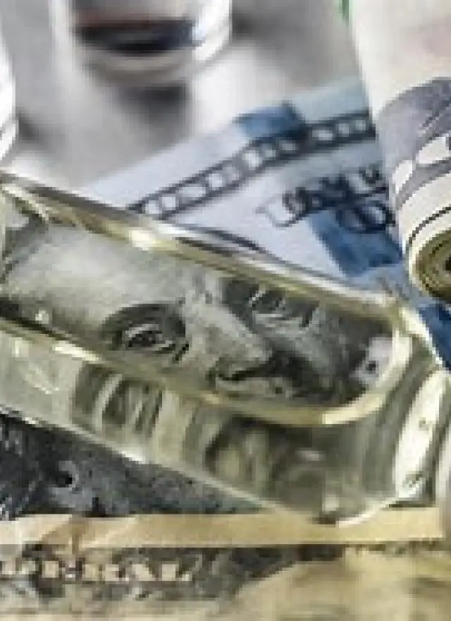 a medical vial on top of a hundred dollar bill