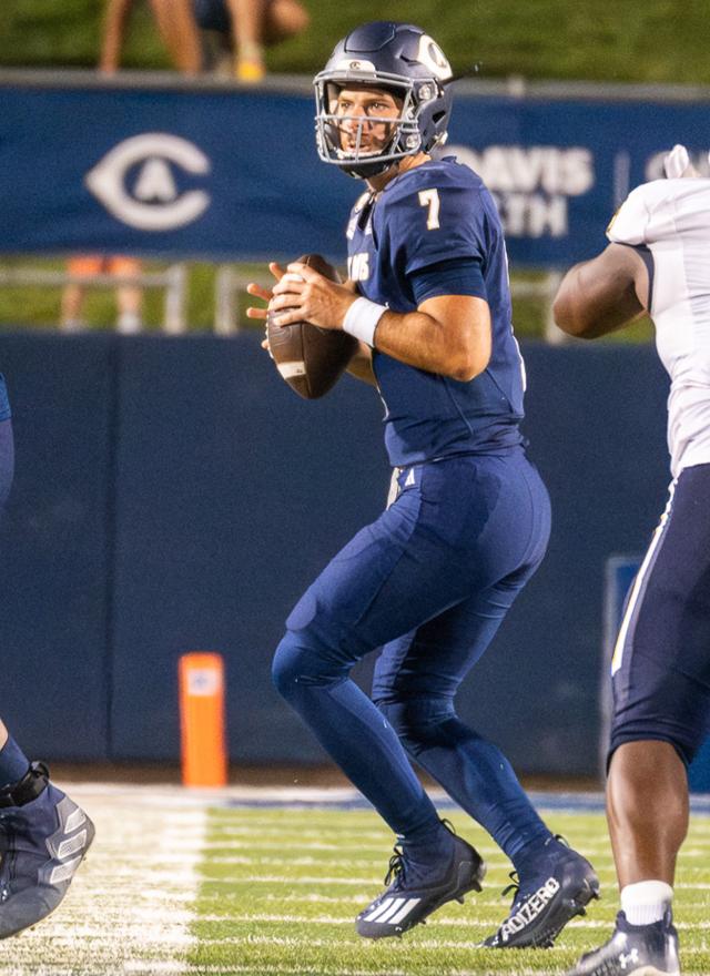 Miles Hastings holding a football on the field