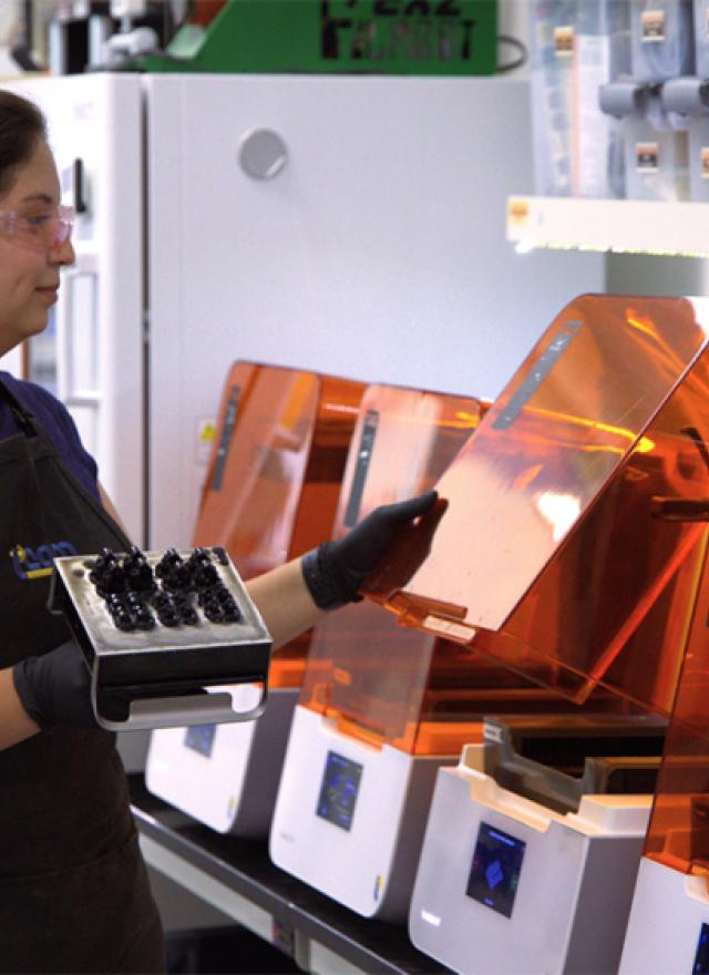 woman standing in front of 3D printers