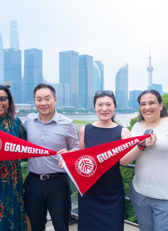 Shannon McPartland and student hold up banners that say Guanghua School of Management.