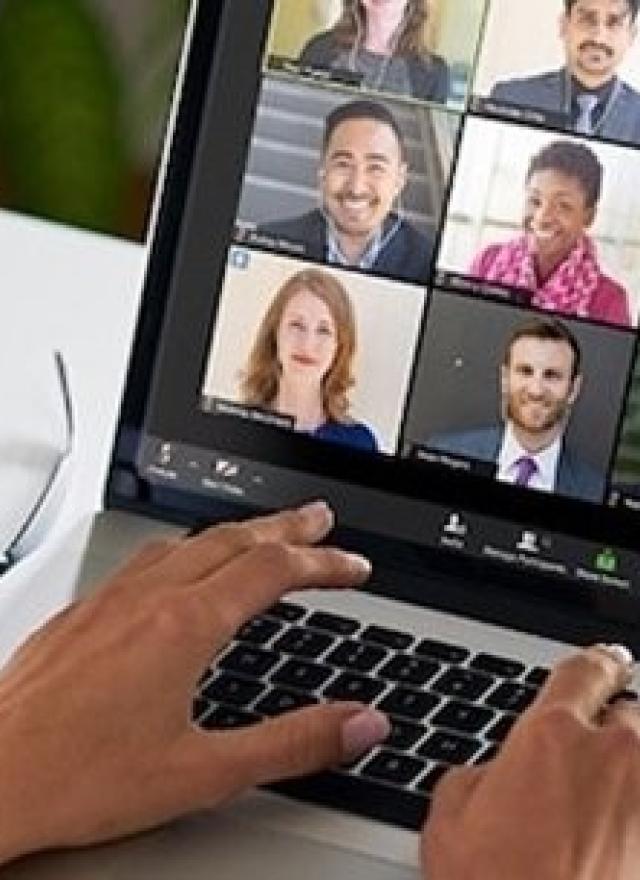 Person in an online meeting on a laptop