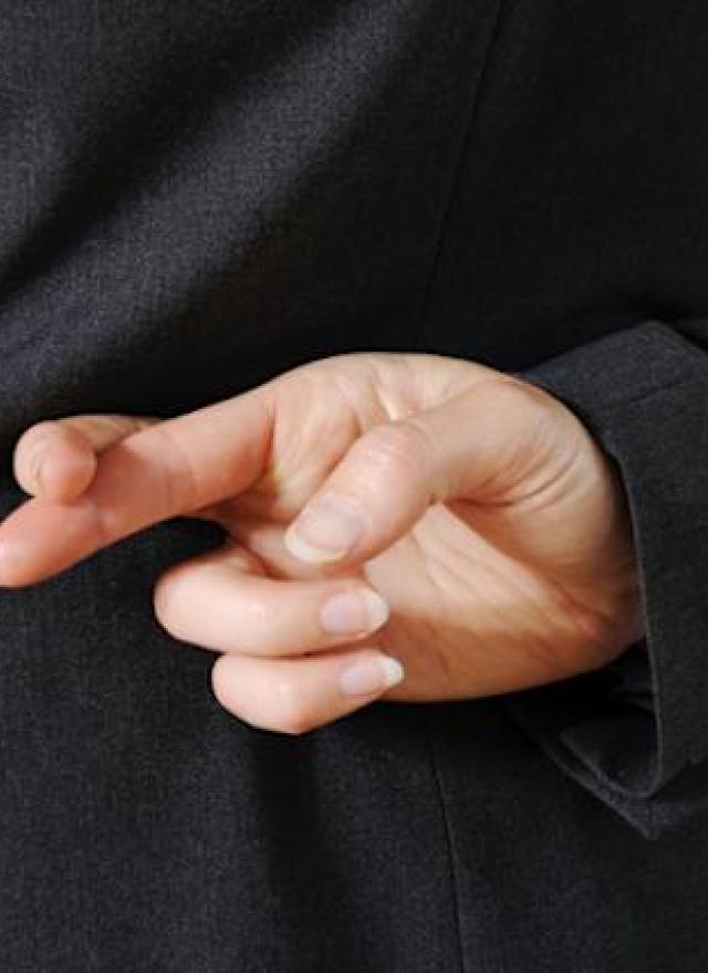 Crossed fingers behind a person's back, indicating fibbing.