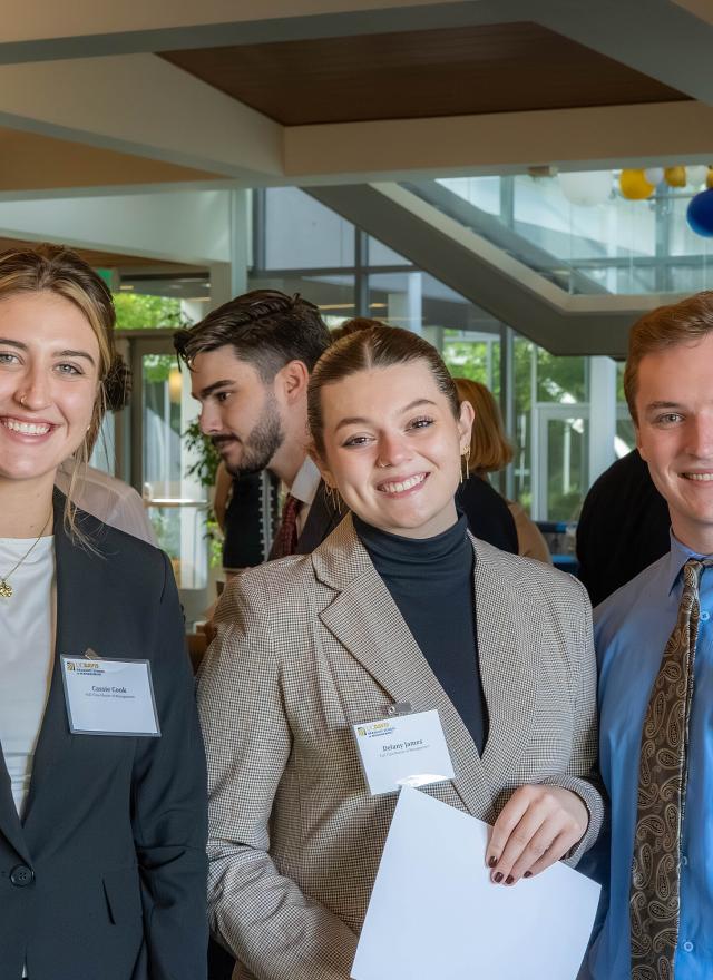 Three students in professional attire in Gallagher Hall