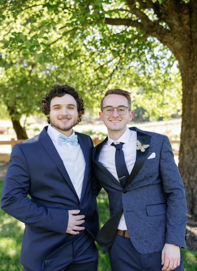 Yamin Elshaer and Dillon Hill standing side-by-side in wedding attire 