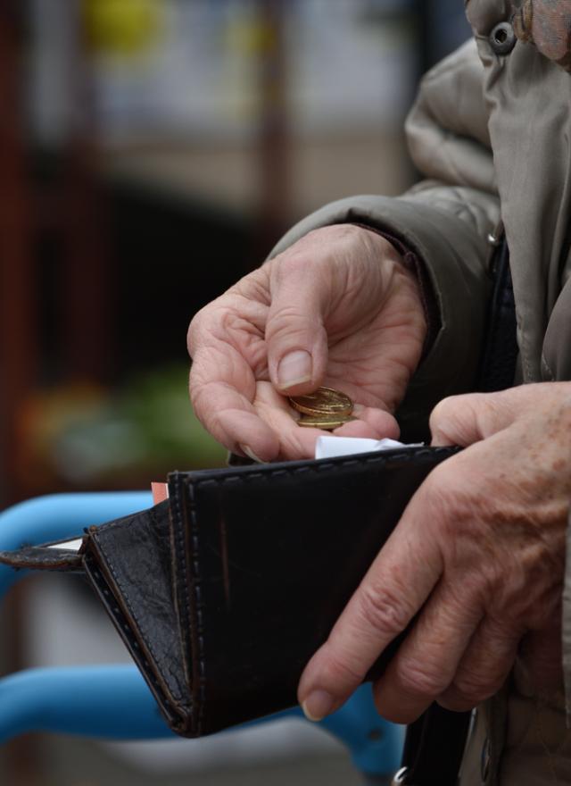 older woman opening a wallet