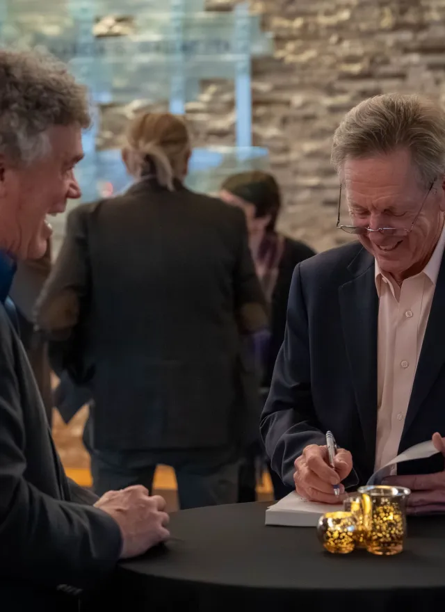 Maurice J. Gallagher Jr. signs copies of his book during a reception at Gallagher Hall after his UC Davis speaker event.