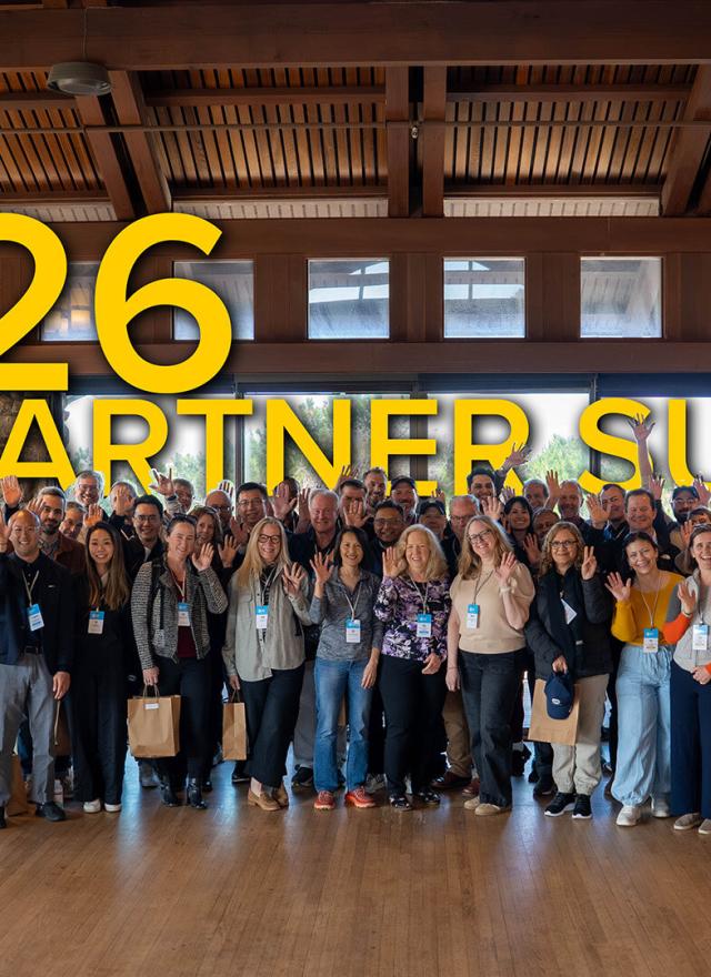A large group of people standing together indoors, smiling and waving, with “2026 IIFH Partner Summit” in large yellow text above them.