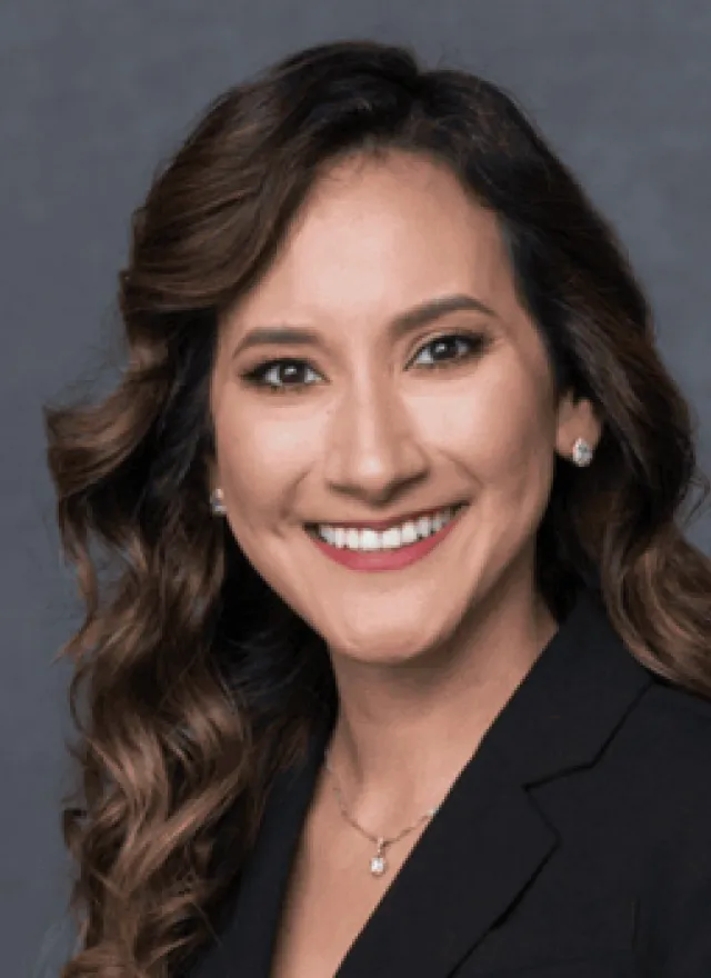 A woman in a black blazer smiles at the camera. Next to her is a “Poets & Quants MBAs to Watch Class of 2026” badge on a gray background.