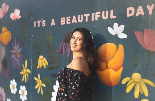 Leticia Garay standing in front of a flower mural
