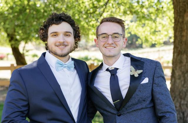 Yamin Elshaer and Dillon Hill standing side-by-side in wedding attire 