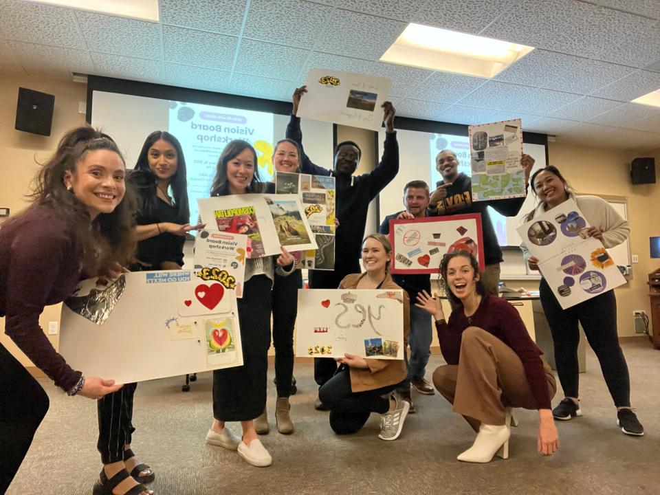 A group of women holding up vision boards