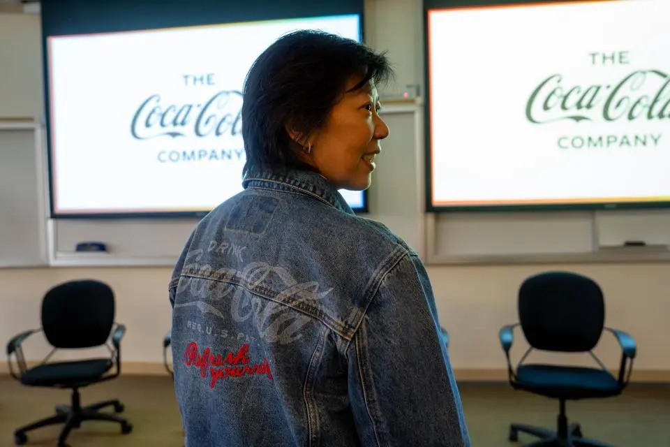 Woman wearing a denim jacket with a Coca Cola logo on the back