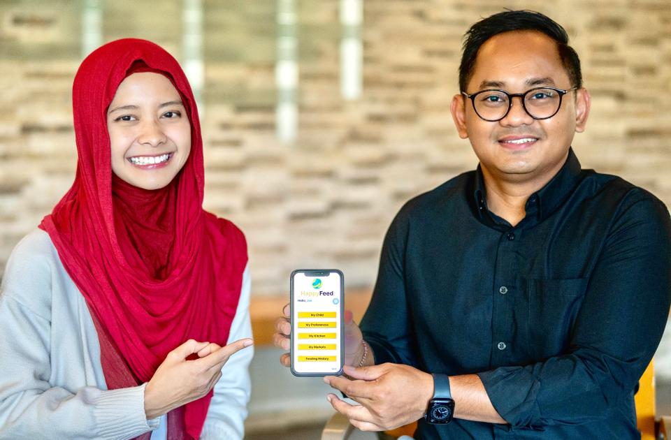 Galih Setiawan holding up iPhone with app