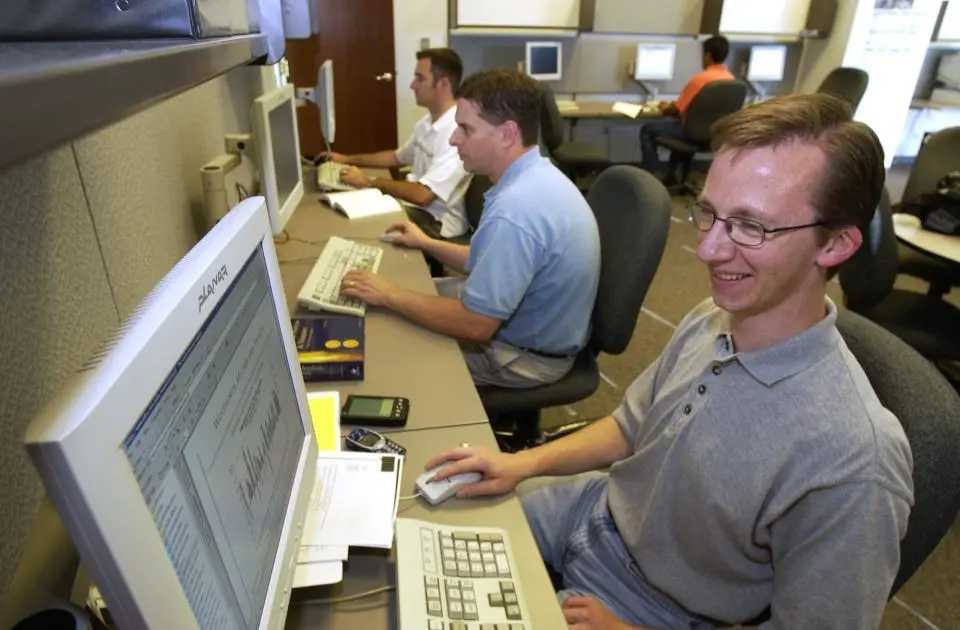 Three MBA students in a computer lab