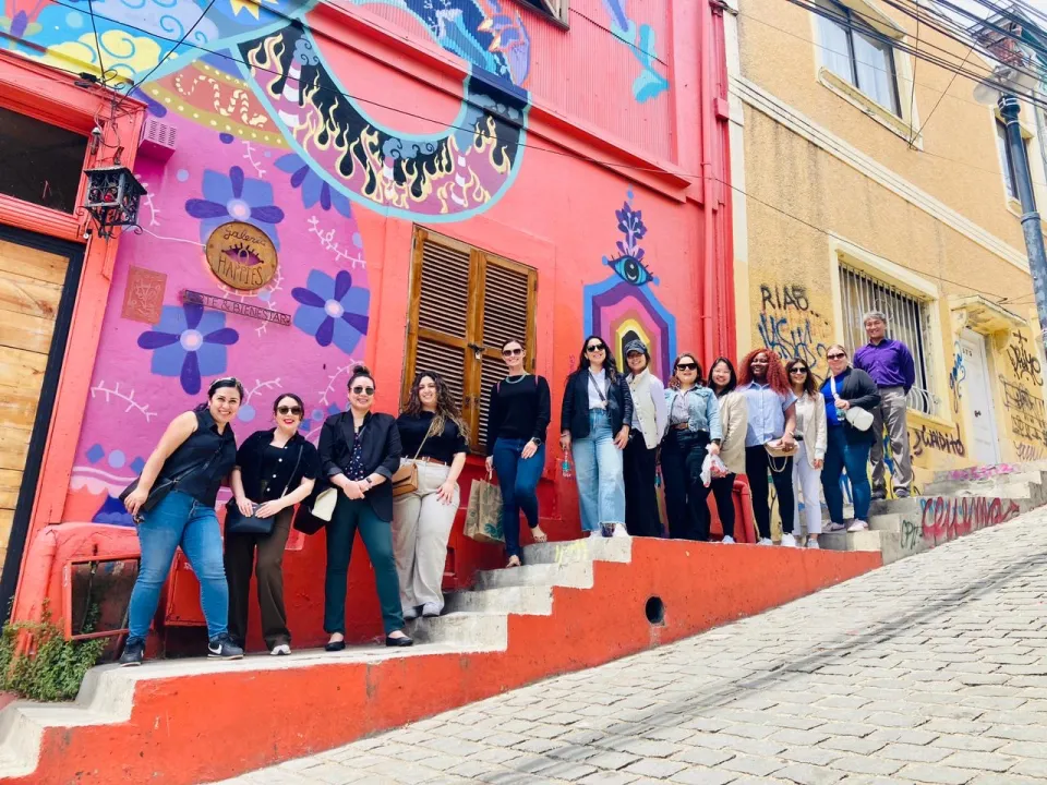 MBA students in Chile in front of a pink and orange mural