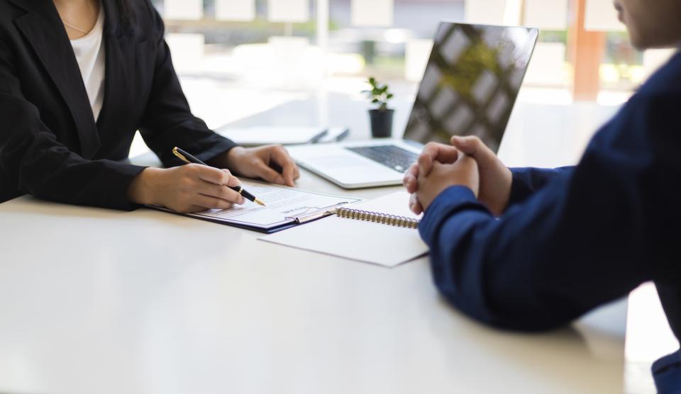 two people sitting at a desk in an office setting