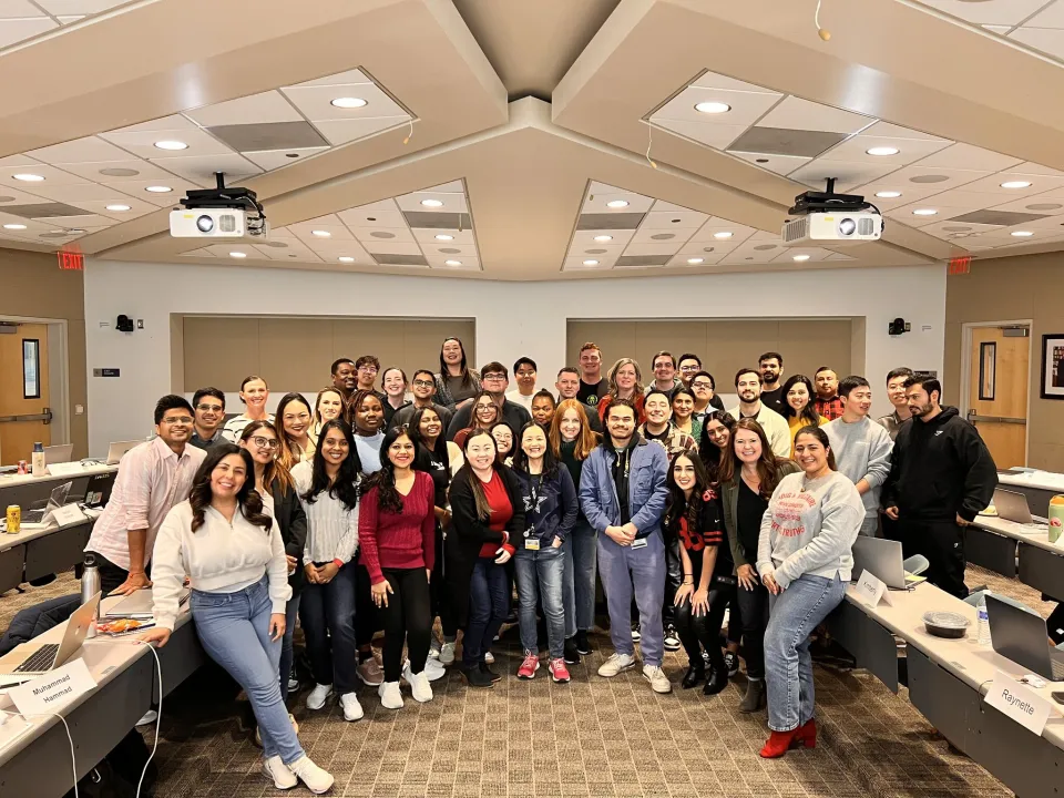 MBA students in a UC Davis MBA classroom, smiling at the camera