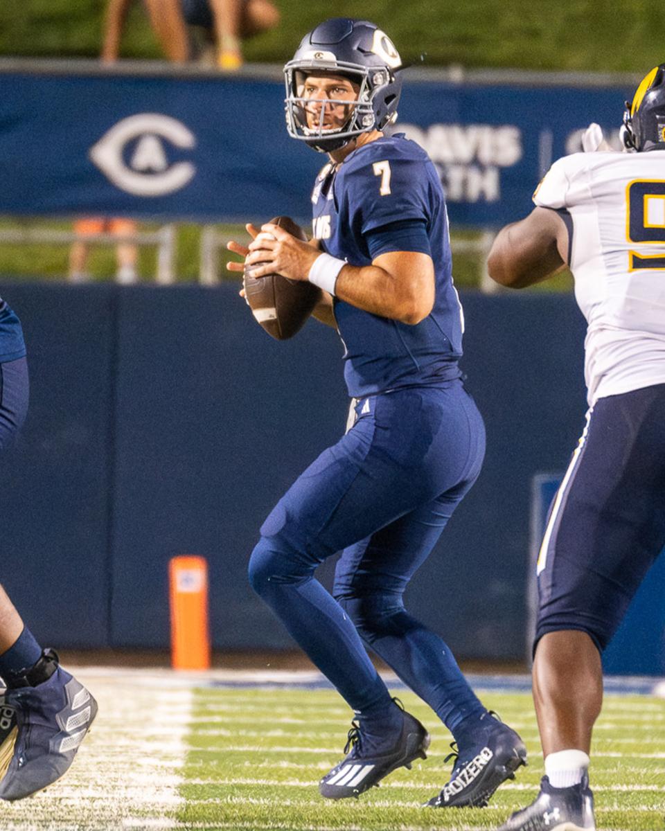 Miles Hastings holding a football on the field