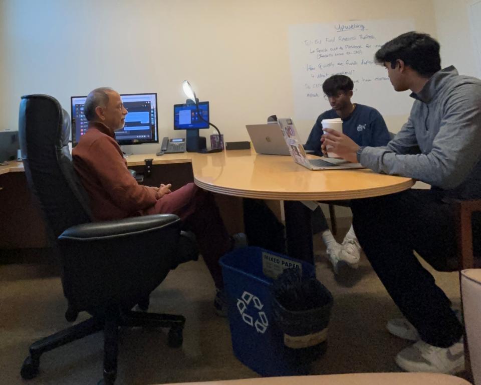 Anirudh Murugesan and Ayan Mani sitting across from Hemant Bhargava