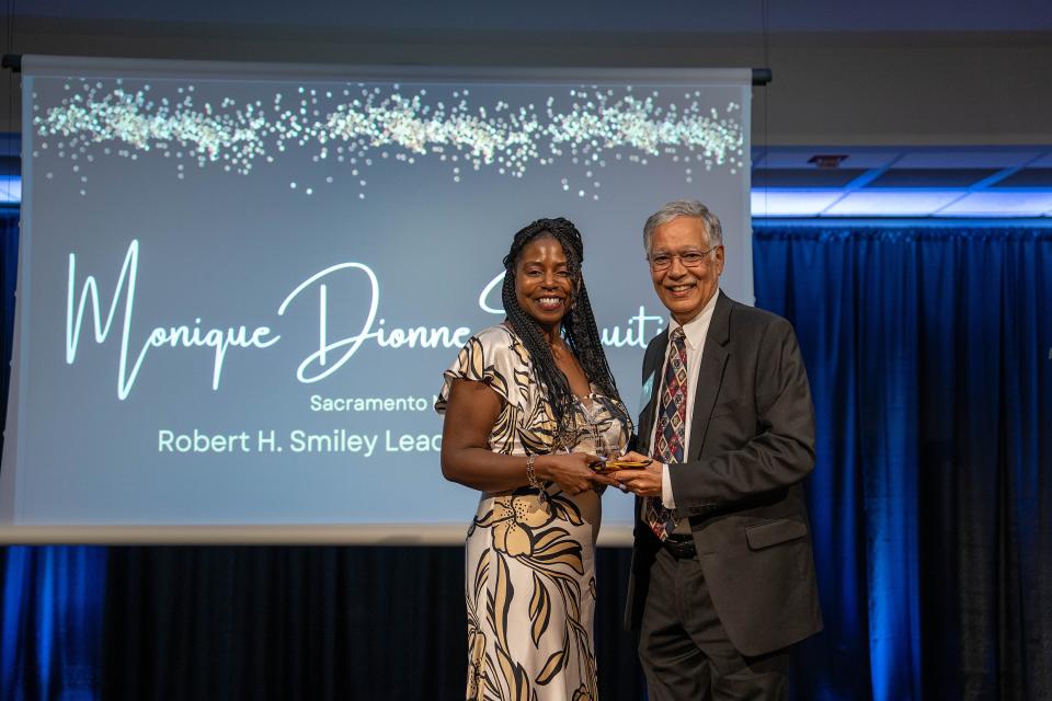 Monique Dionne Fruitier on-stage receiving award from Dean Rao Unnava