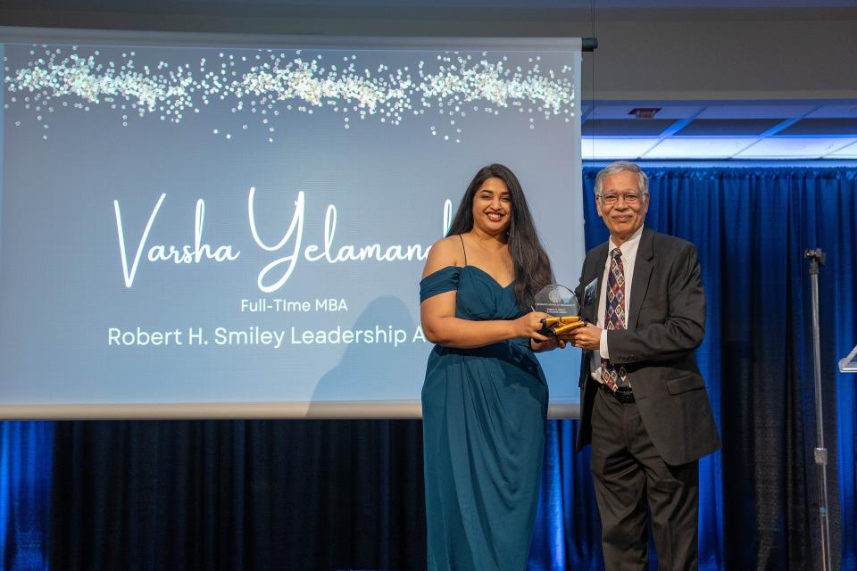Varsha Yelamanchi on stage receiving award from Dean Rao Unnava