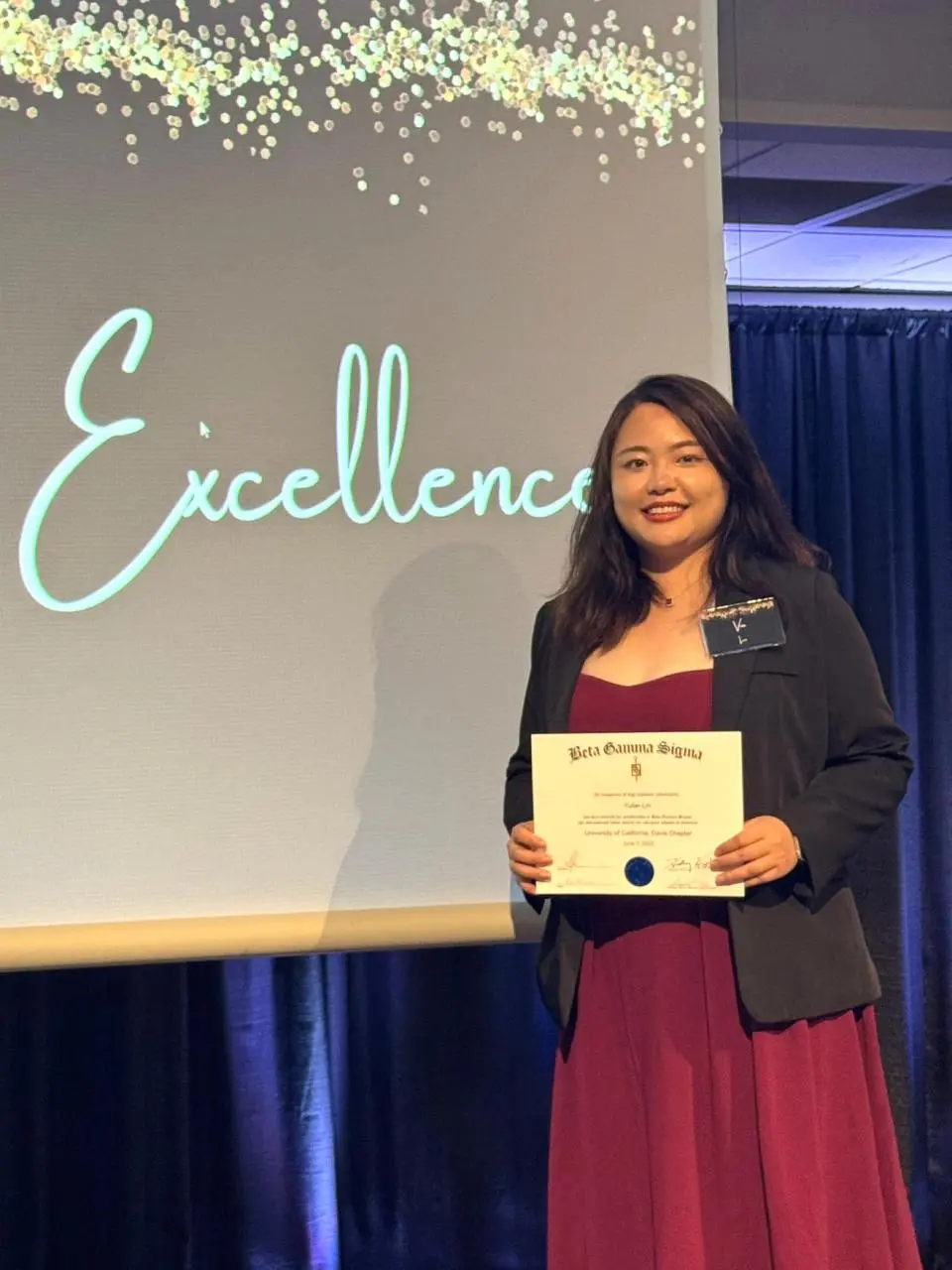 Via Lin holding up a certificate 