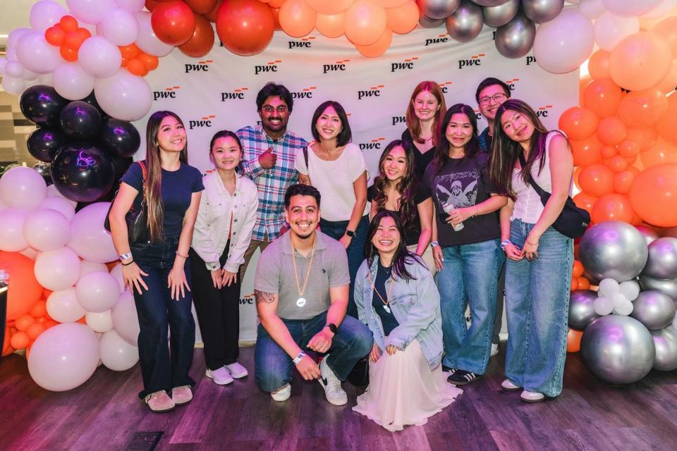 Diana Tran with her PwC associates at a firm event with banners and baloons