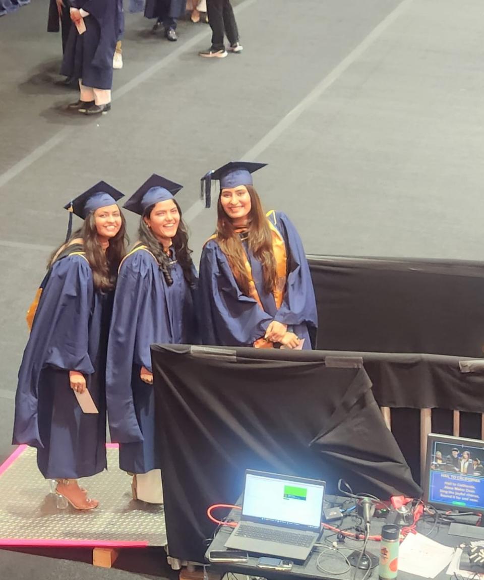 three graduates in cap and gowns 
