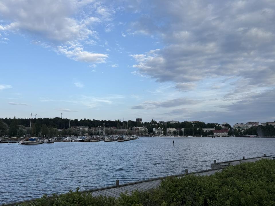 Lake Saimaa in Lappeenranta, Finland, with sailboats docked at the marina and a bright blue sky with scattered clouds overhead