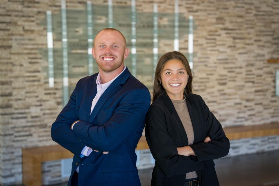 Two people standing in the Gallagher Hall lobby