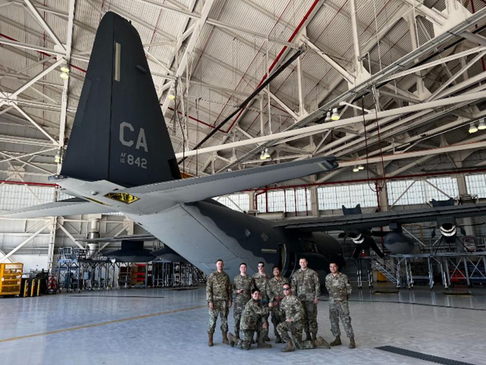 Andre Paradiang (top row, fourth from left) stands with his Air Force unit in front of a C-130 aircraft during his military career