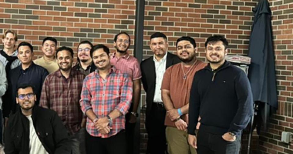MBA students in front of a brick wall