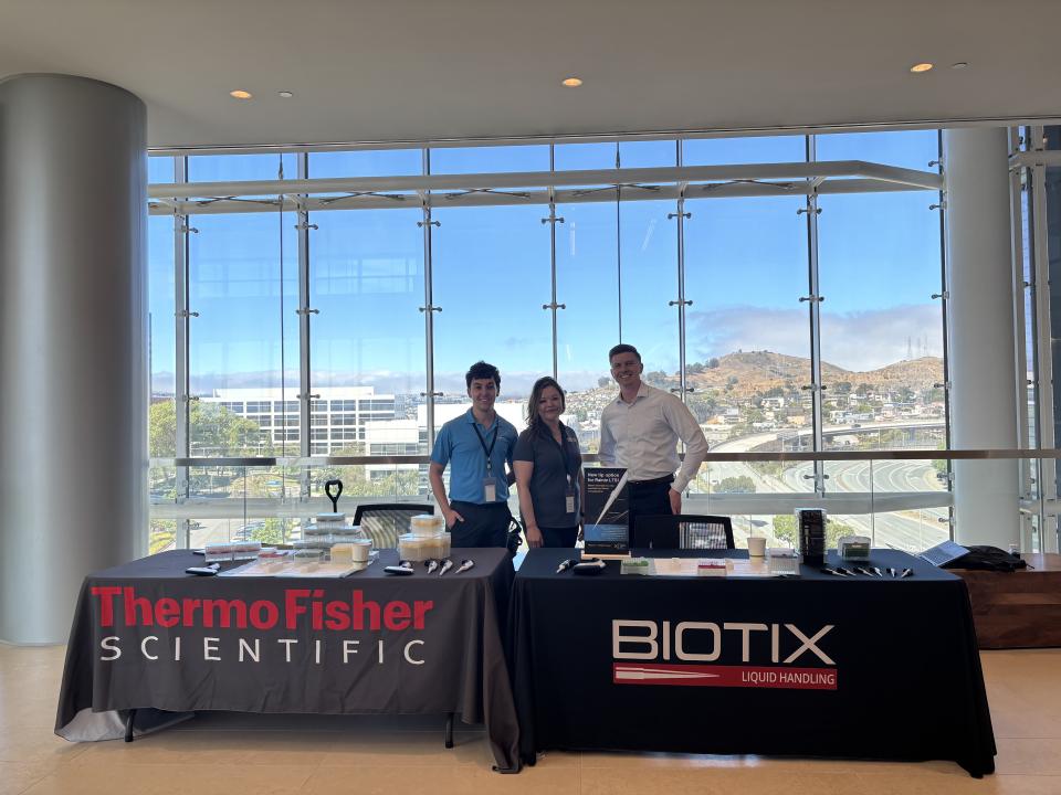 Jason Bartus standing behind a vendor table for Thermo Fischer 