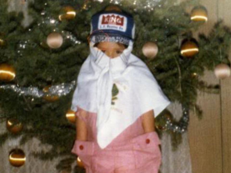 Meslissa at age 3, wearing a white button up short and hat