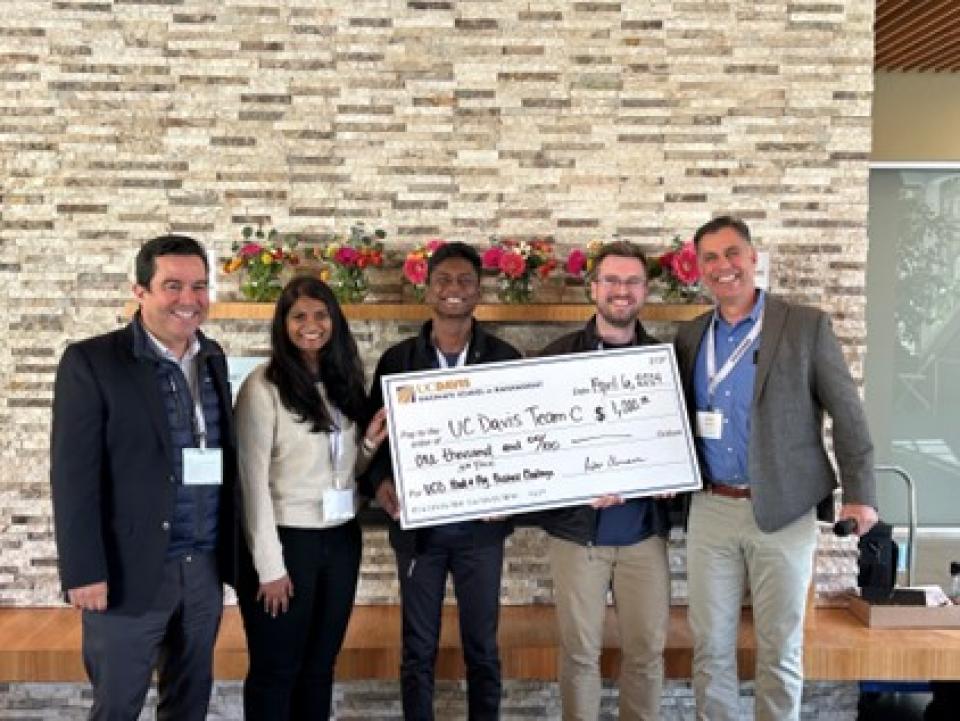 Roshan Paul, Sushmitha Kala and Nick McKenna holding a giant check