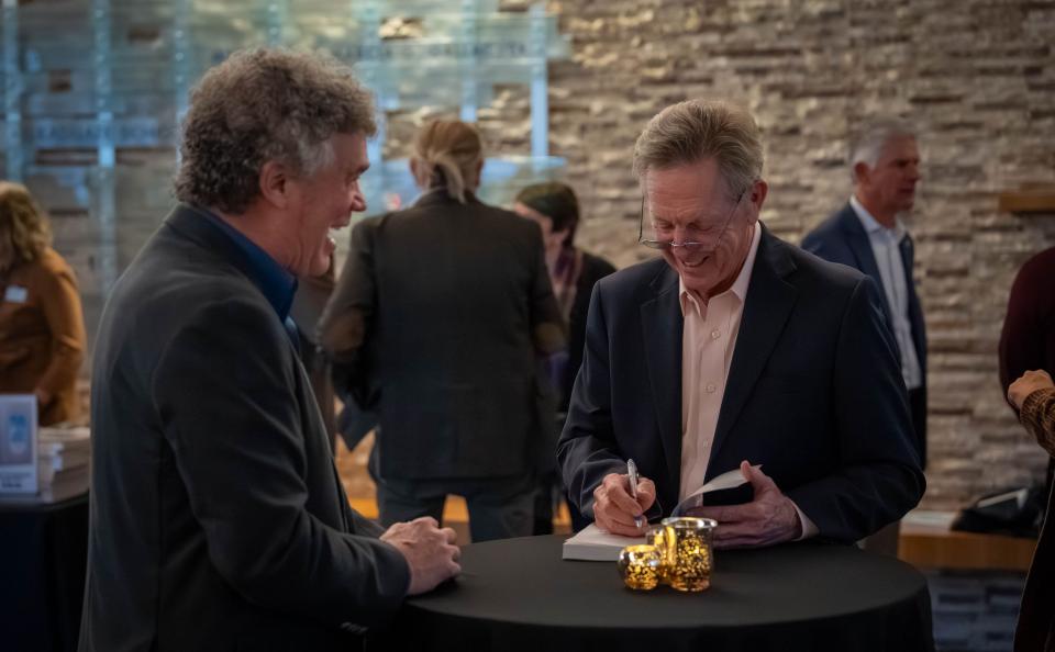 Maurice J. Gallagher Jr. signs copies of his book during a reception at Gallagher Hall after his UC Davis speaker event.