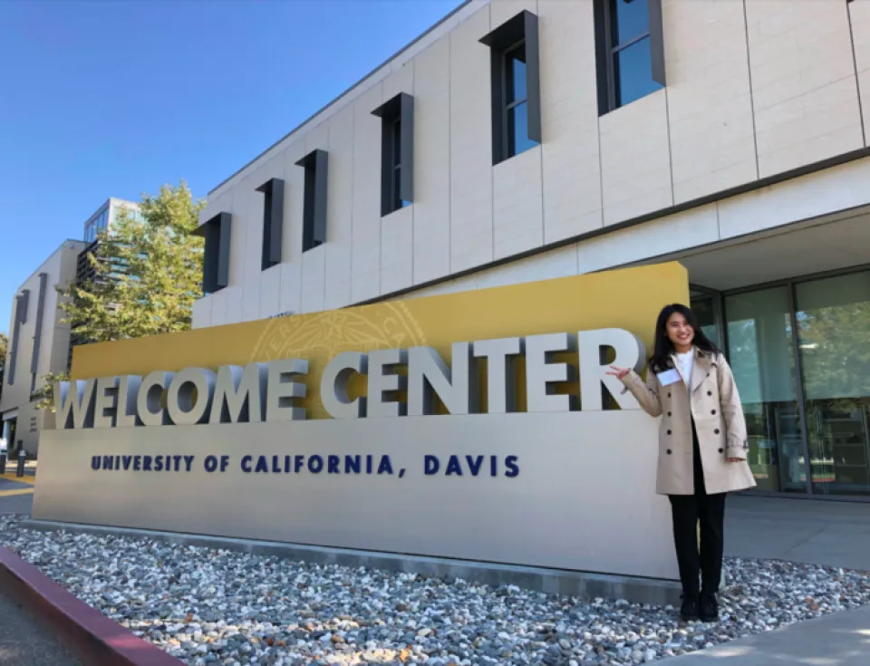 Beverly Huang with a UC Davis sign at the welcome center on the Davis campus