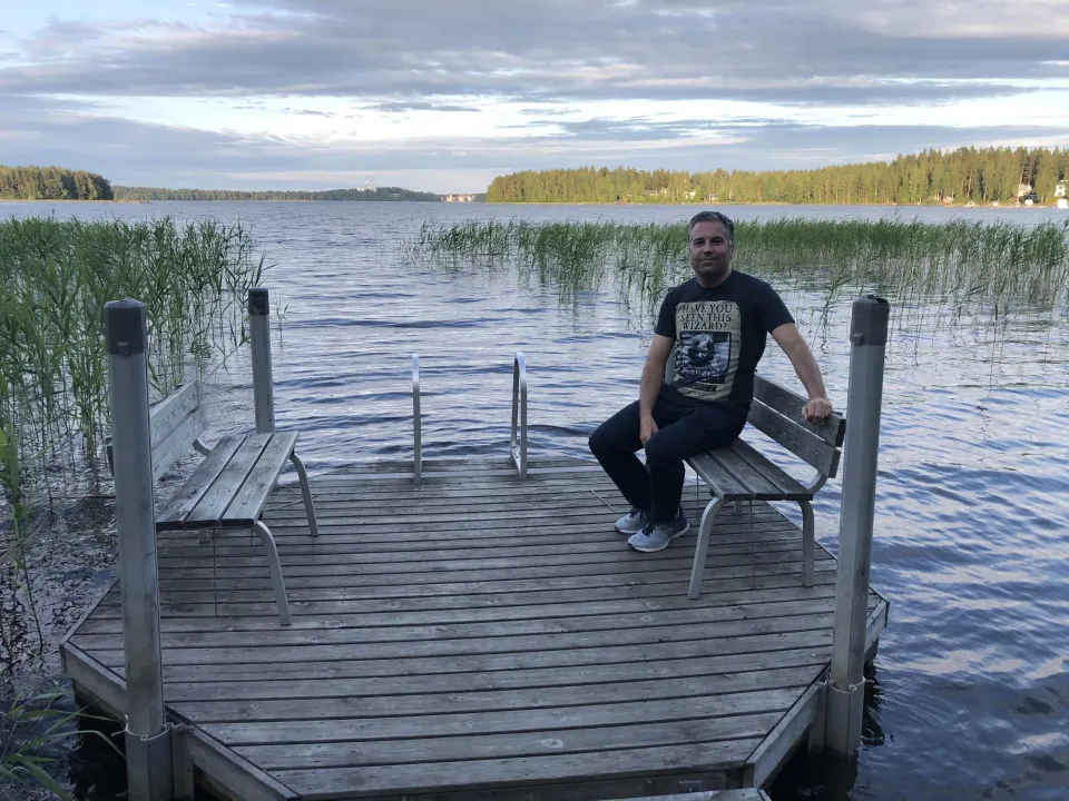 Daniel Student on a bench on a boardwalk on a lake