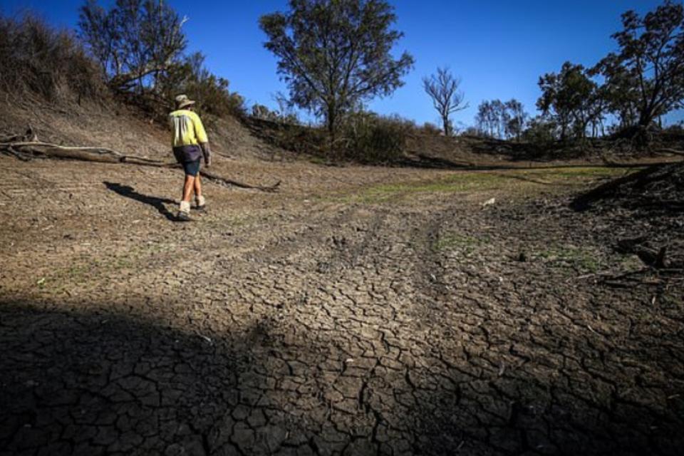 Person walking along dried up soil path