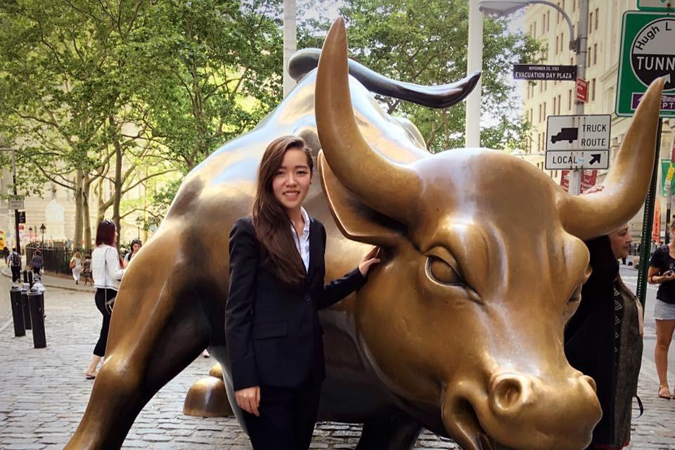 Lizzy Yi MSBA 21 takes a photo with the famous 'Charging Bull' on Wall Street